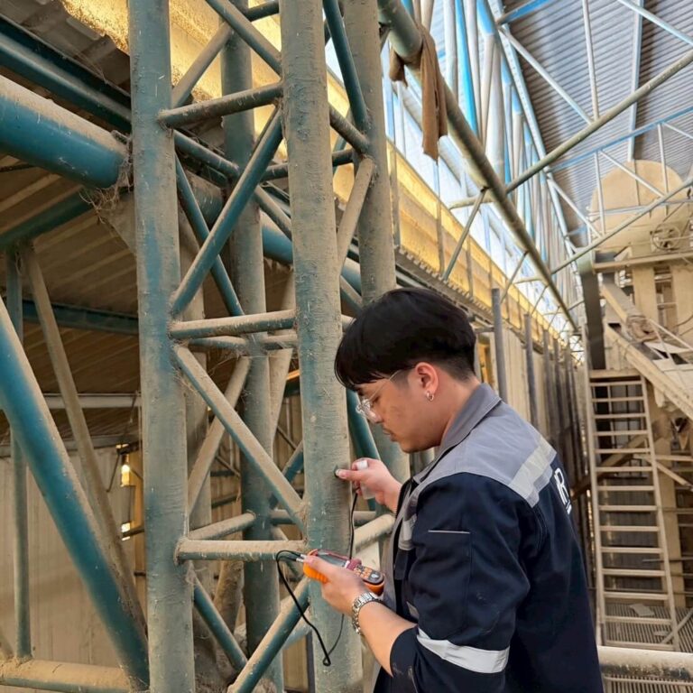 วิศวกรใช้เครื่องมือวัดตรวจโครงสร้างเหล็กของหอโครงถัก